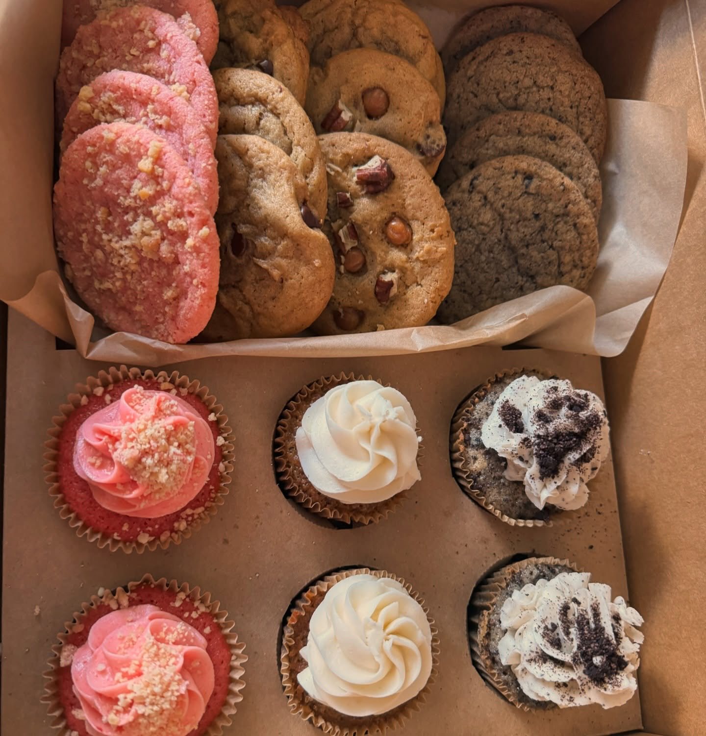 A box of assorted cookies and cupcakes